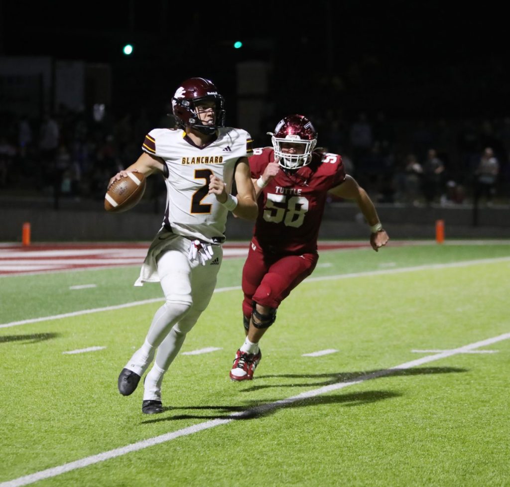 Senior QB Hudsen Periman looks to pass as the Tuttle defense closes in. (PHOTO BY JAYSON KNIGHT)