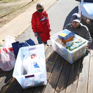 Tyler Sanders, Midwest City Beacon circulation manager, helps unload boxes of food from the holiday food drive Dec. 19 at the Mid-Del Food Pantry. photo by Jeff Harrison